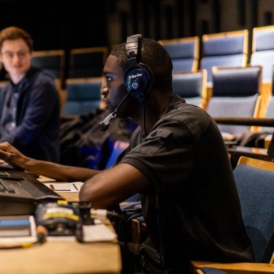 Production arts students working at a lighting desk